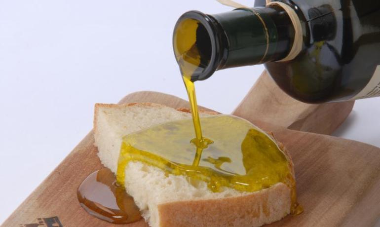 Pane con olio d'oliva su tagliere di legno.