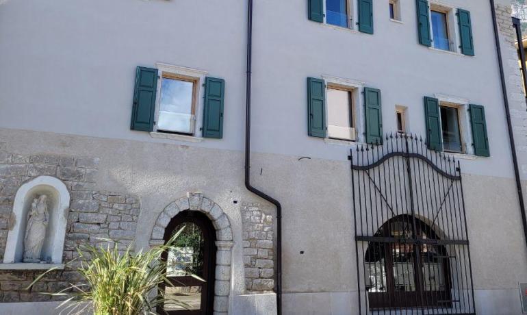 Historic building with green shutters, blue sky, serene and warm atmosphere.