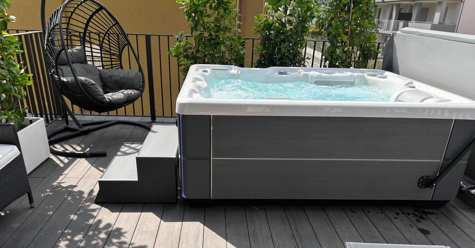 Terrasse mit Whirlpool, Hängesessel und sonniger Entspannung.