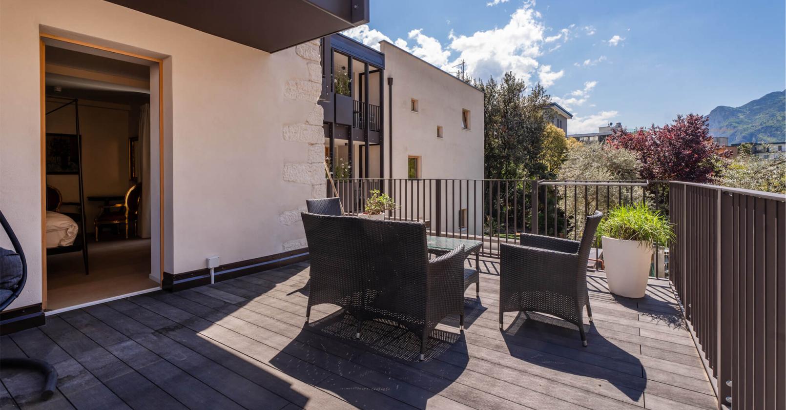 Sonnige Terrasse mit Bergblick, elegante Möbel und entspannte Atmosphäre.