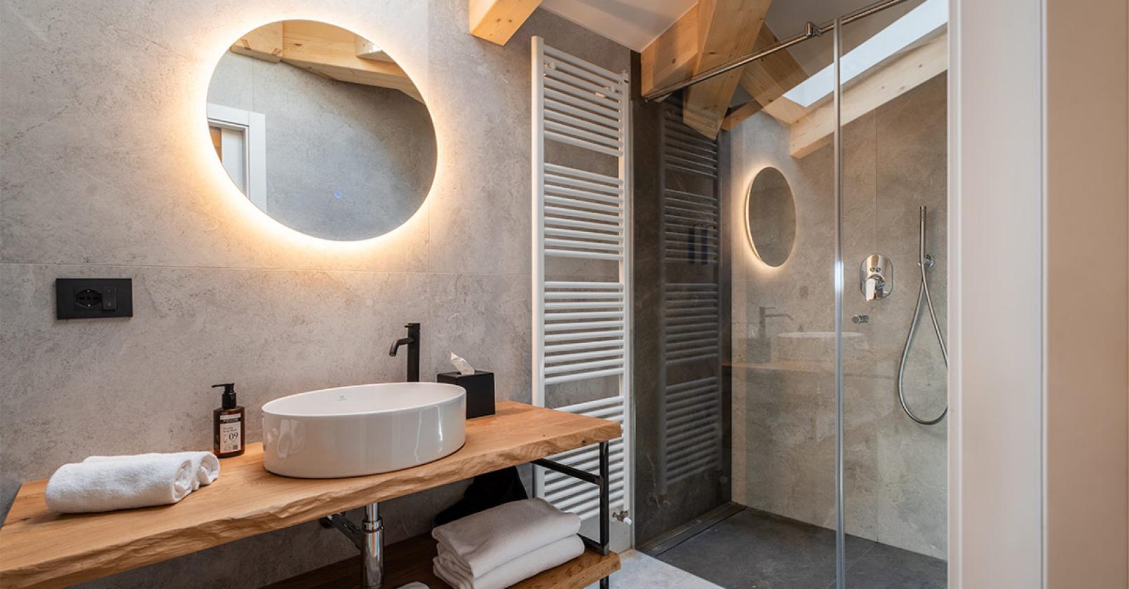 Bagno moderno e accogliente con specchio luminoso e doccia elegante.
