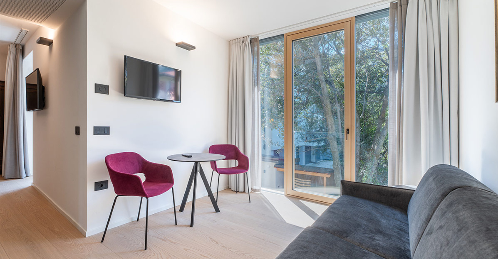 Camera moderna con TV e balcone.