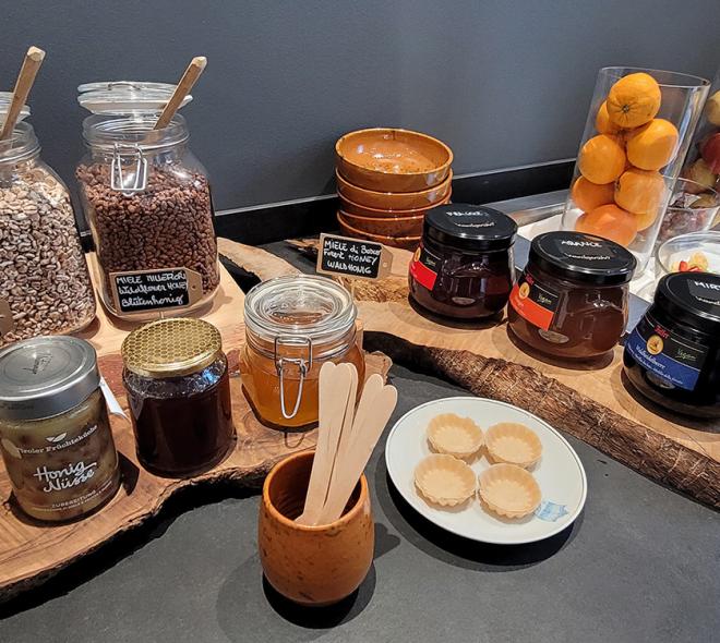 Rustic breakfast with honey, cereals, and jams, warm and inviting colors.