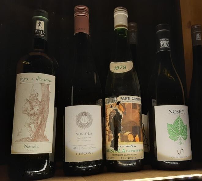 Cinque bottiglie di vino Nosiola, annate varie, evocano storia e tradizione.